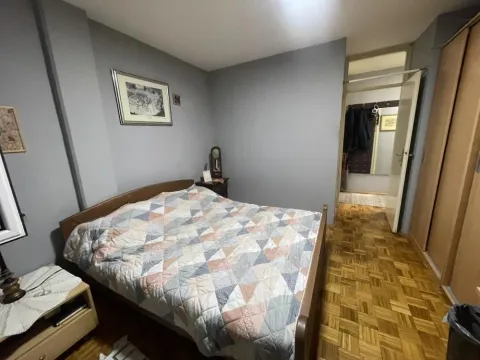 Spavaća soba sa bračnim krevetom, drvenim podom i ormarom. - image 10