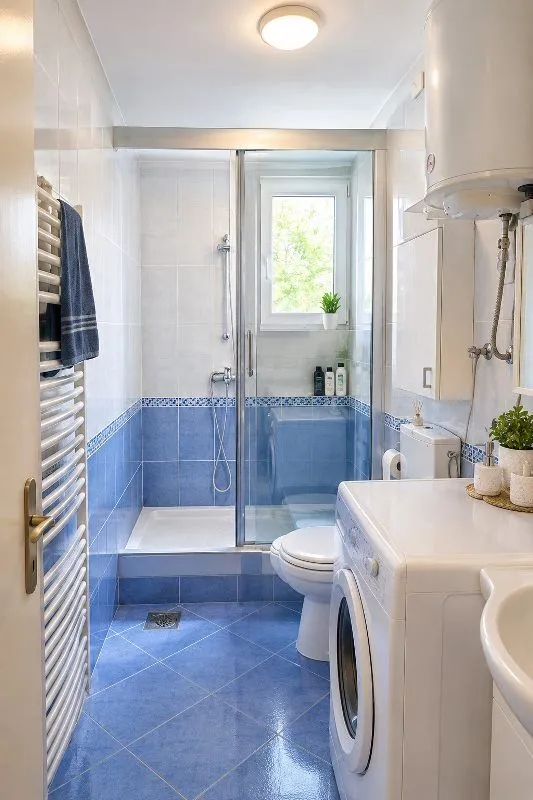 Compact bathroom with a shower cabin, toilet, and washing machine.