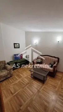 Dnevna soba sa garniturom za sedenje, stočićem i televizorom. - image 22