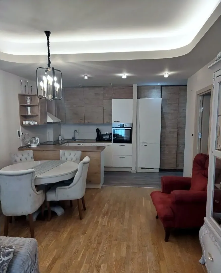 Spacious living room with a dining area and kitchen in the background.