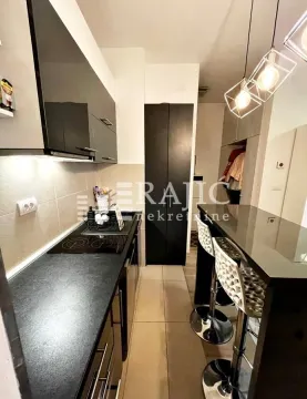 Modern kitchen with a bar and dining counter. - image 3
