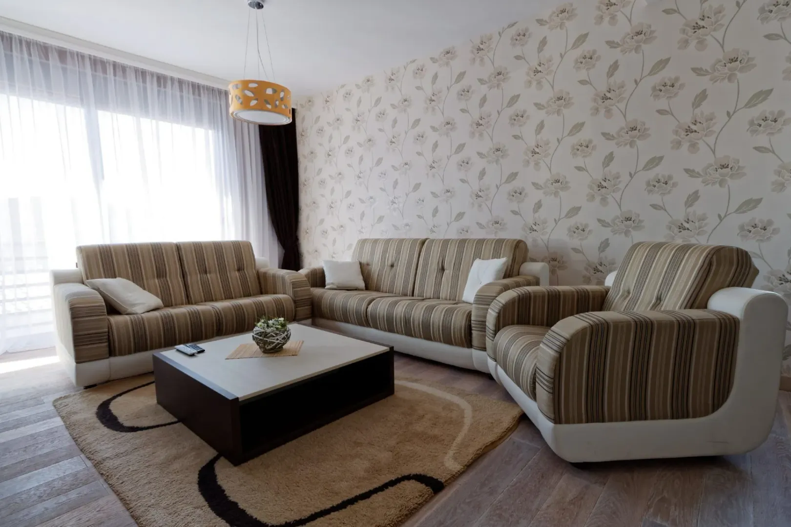 Svijetao dnevni boravak sa garniturom za sjedenje i stočićem.