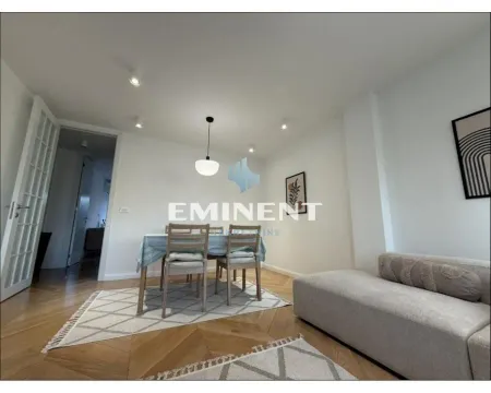 Living room with a dining area and a sofa. - image 2