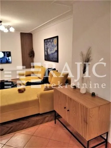 Living room with a yellow sofa, sideboard, and a painting on the wall.