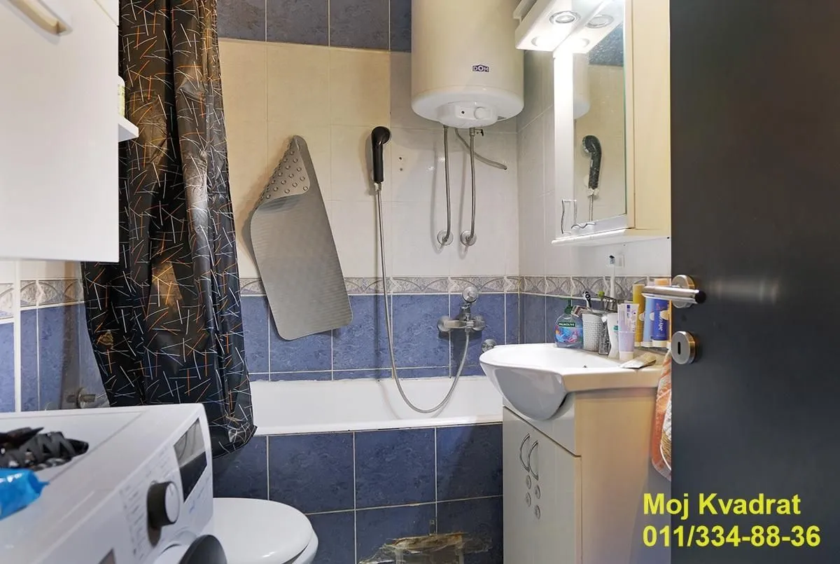 Manje kupatilo sa kadom, umivaonikom, bojlerom i veš mašinom.