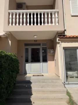 Ulaz u stambenu zgradu sa stepeništem i balkonom na spratu. - image 3