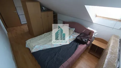Furnished attic bedroom with a bed and a wardrobe. - image 3