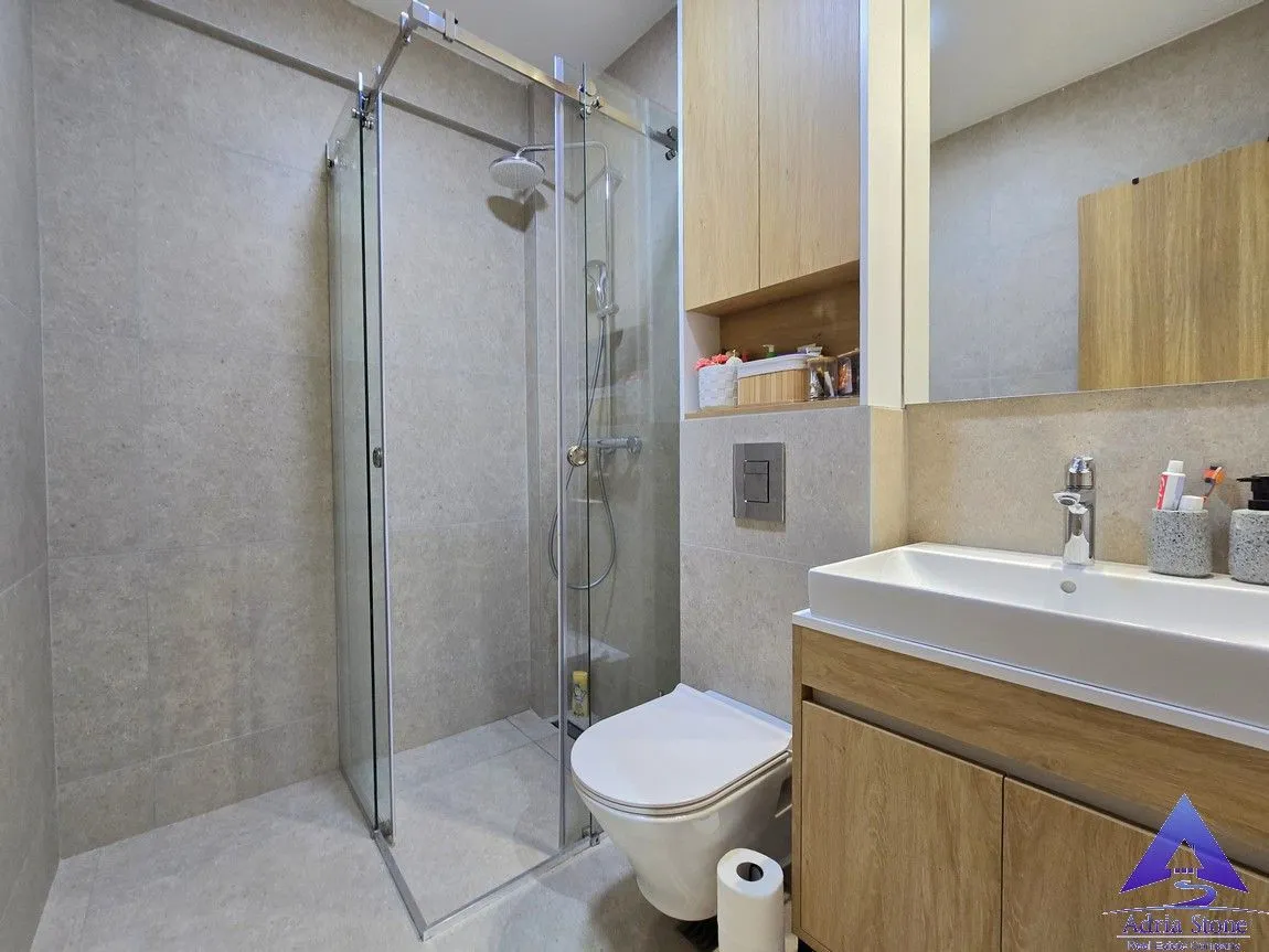 Moderno opremljeno kupatilo sa tuš kabinom, umivaonikom i WC šoljom.