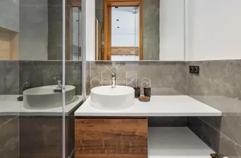 Modern bathroom with a countertop washbasin, mirror, and shower enclosure. - image 11