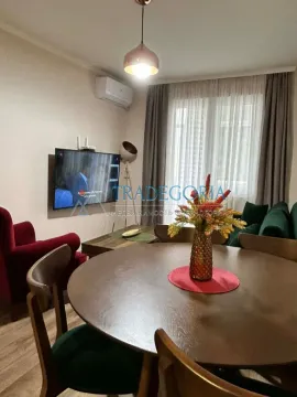 Dnevni boravak sa trpezarijskim stolom i televizorom na zidu. - image 6