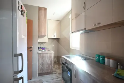 Small kitchen with wooden elements, a sink, and a built-in oven. - image 8