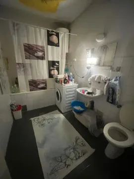 Kupatilo opremljeno kadom, umivaonikom, toaletom i veš mašinom. - image 5