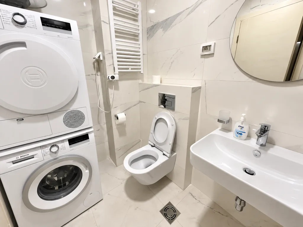 Modern bright bathroom with a washing machine, towel warmer, toilet, and washbasin.