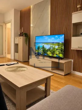 Living room with wooden wall panels and a television. - image 8