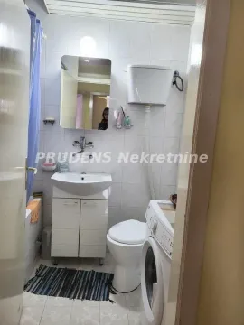 Smaller bathroom with a sink, toilet, bathtub, and washing machine. - image 15