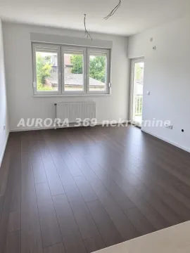Prazna neopremljena soba sa tamnim parketom i prozorima. - image 2