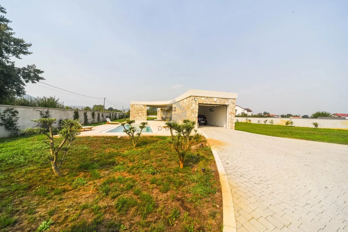 Exterior of the house with yard, swimming pool and garage.