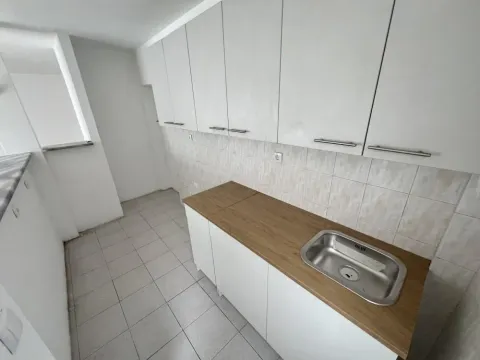 Manja kuhinja sa belim elementima i drvenom radnom površinom. - image 5