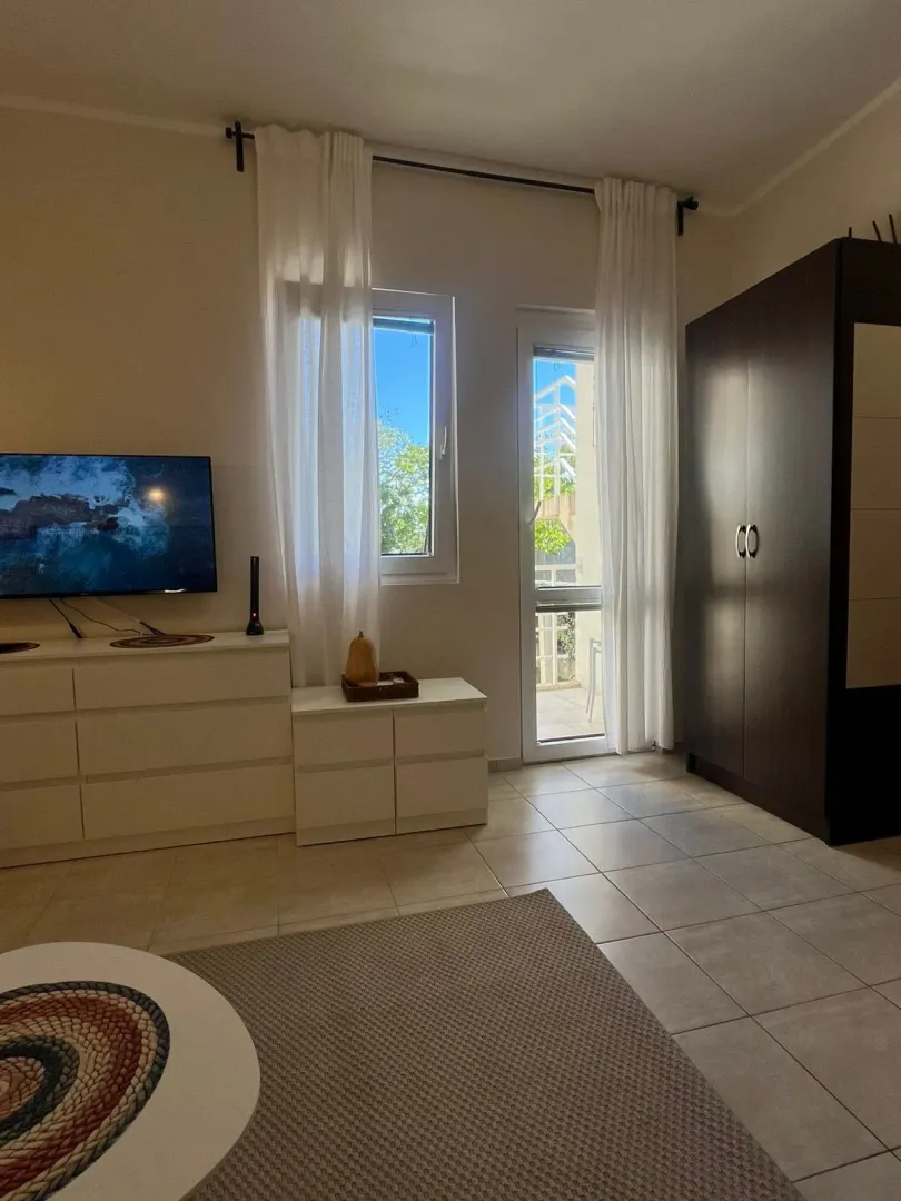 Bright bedroom with a wardrobe, chest of drawers, and access to the terrace.