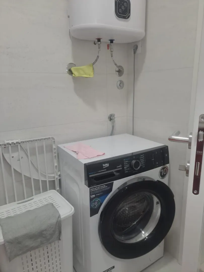 Small bathroom with a washing machine and boiler.