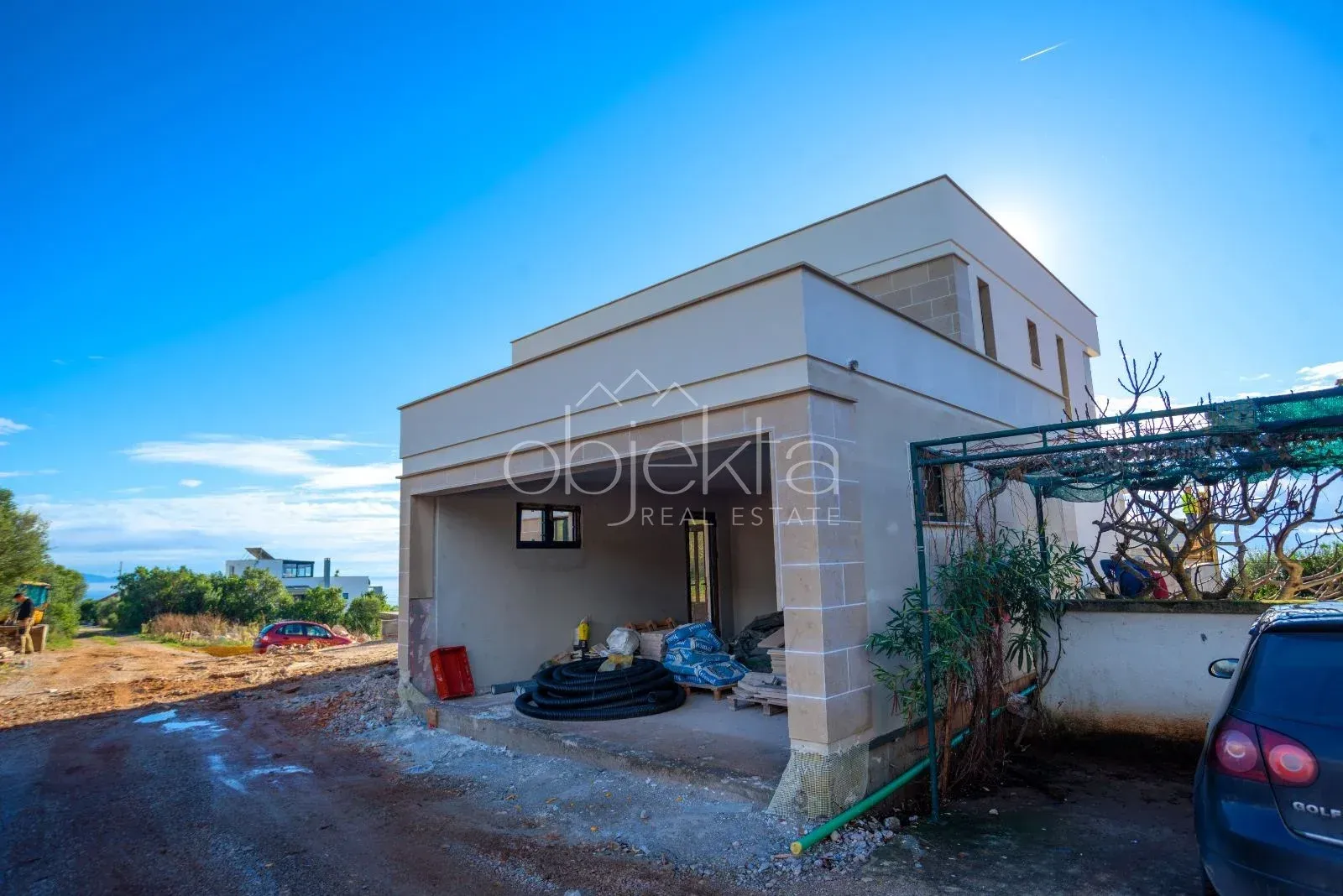 Exterior of a house under construction with a yard and driveway.