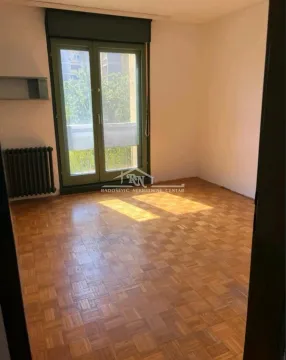 Empty room with hardwood parquet flooring and balcony doors. - image 6