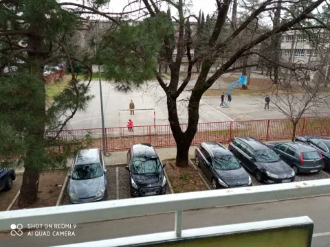 View from the balcony overlooking a parking area and a sports court. - image 16