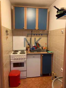 Small kitchen with stove, refrigerator, and upper cabinets. - image 3