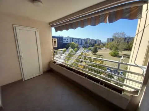 Covered balcony with a view of the city and green areas. - image 9