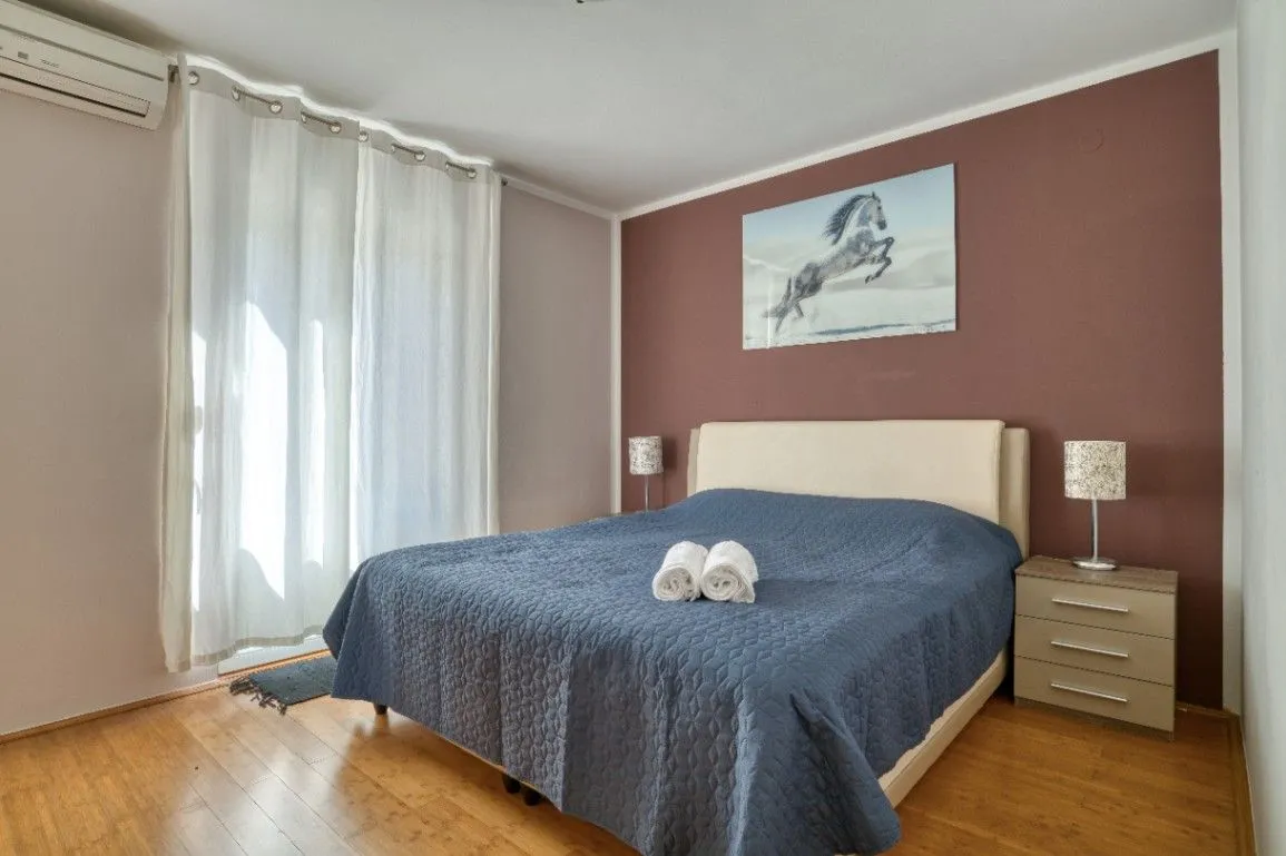 Furnished bedroom with a double bed and balcony access.