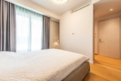 Svjetla spavaća soba sa bračnim krevetom, drvenim podom i prozorom sa zavjesama. - image 20