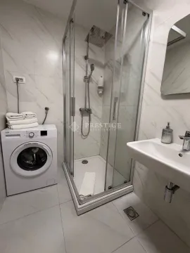 Savremeno opremljeno kupatilo sa tuš kabinom i veš mašinom. - image 10