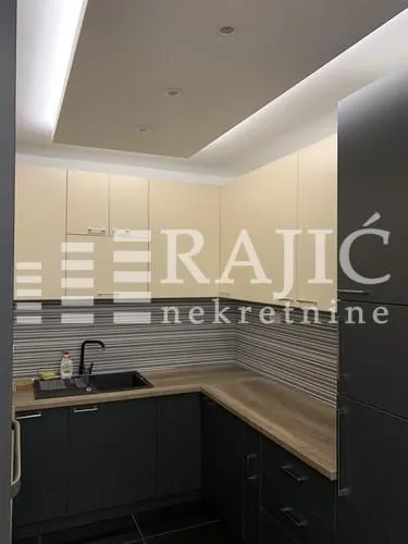 Small kitchen with dark cabinets and recessed lighting.