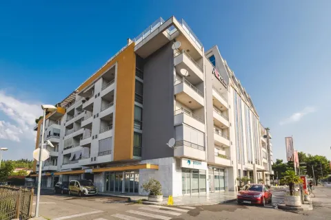 Exterior view of a modern multi-story residential and commercial building with parking. - image 2