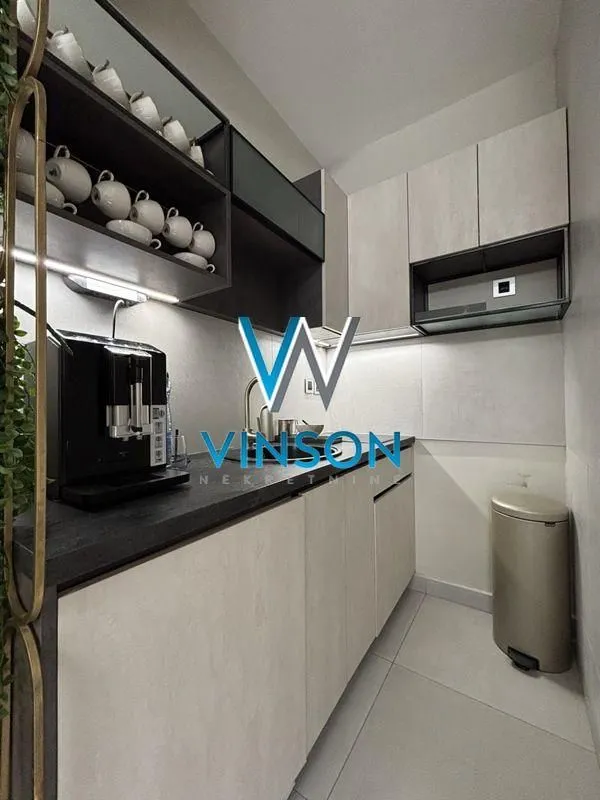 Modern and compact kitchen with built-in units and a coffee machine.