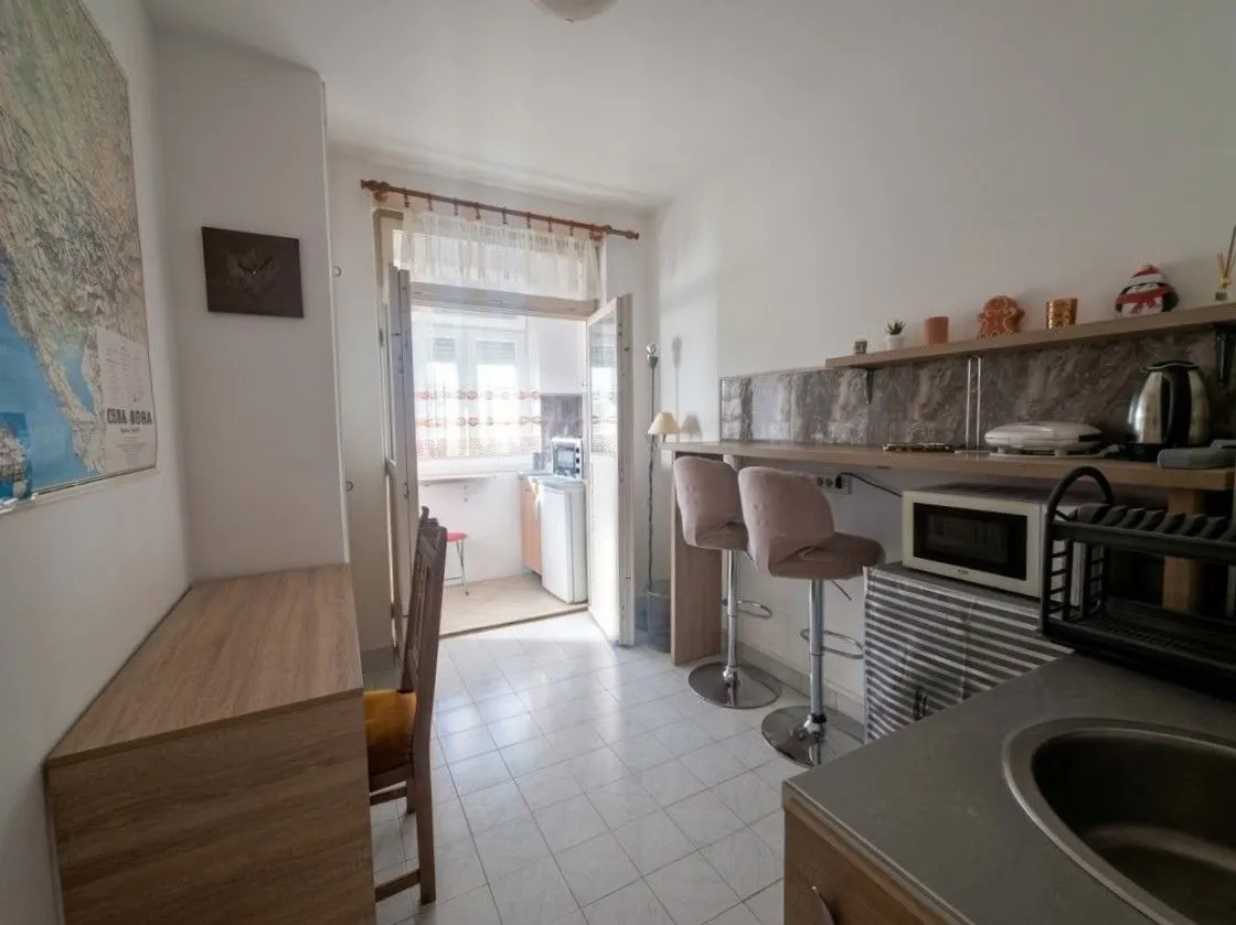 Small kitchen with a bar counter and access to the terrace.