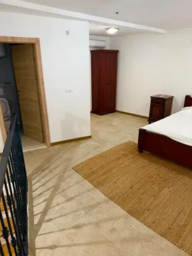Furnished bedroom with a double bed, wardrobe, and bedside table. - image 4