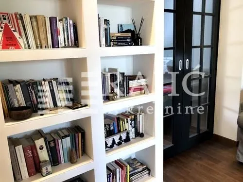 White built-in bookshelf with books in the interior.