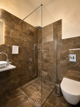 Moderne kupatilo obloženo smeđim mermerom sa tuš kabinom i ugradnim sanitarijama. - image 14