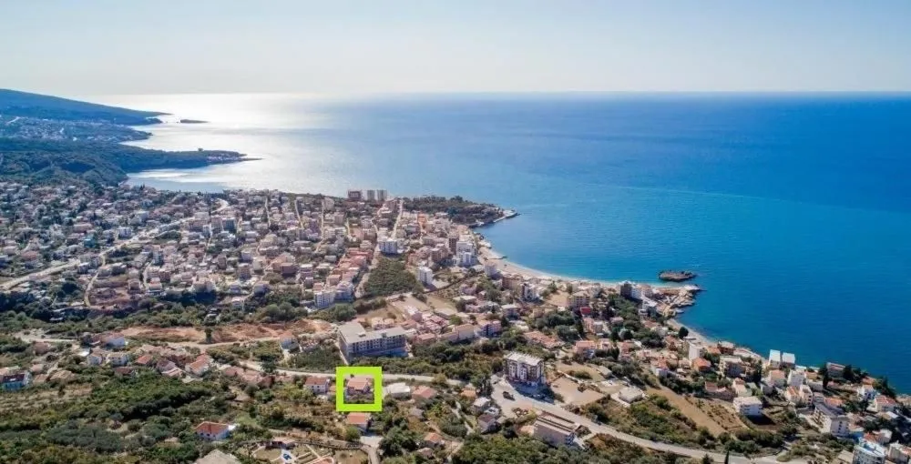 Pogled iz vazduha na priobalno naselje i more sa označenom lokacijom nekretnine.