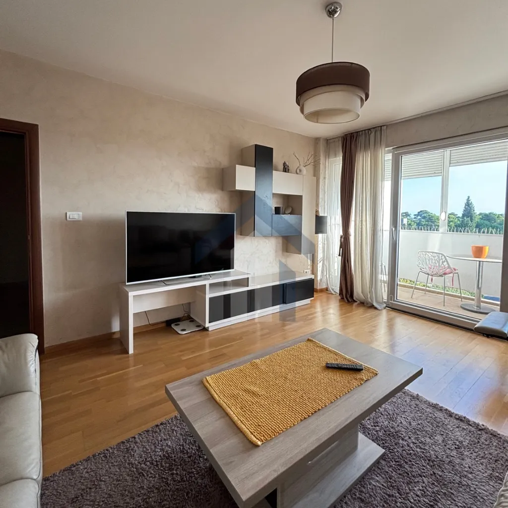 Living room with furniture, TV unit, and terrace access.