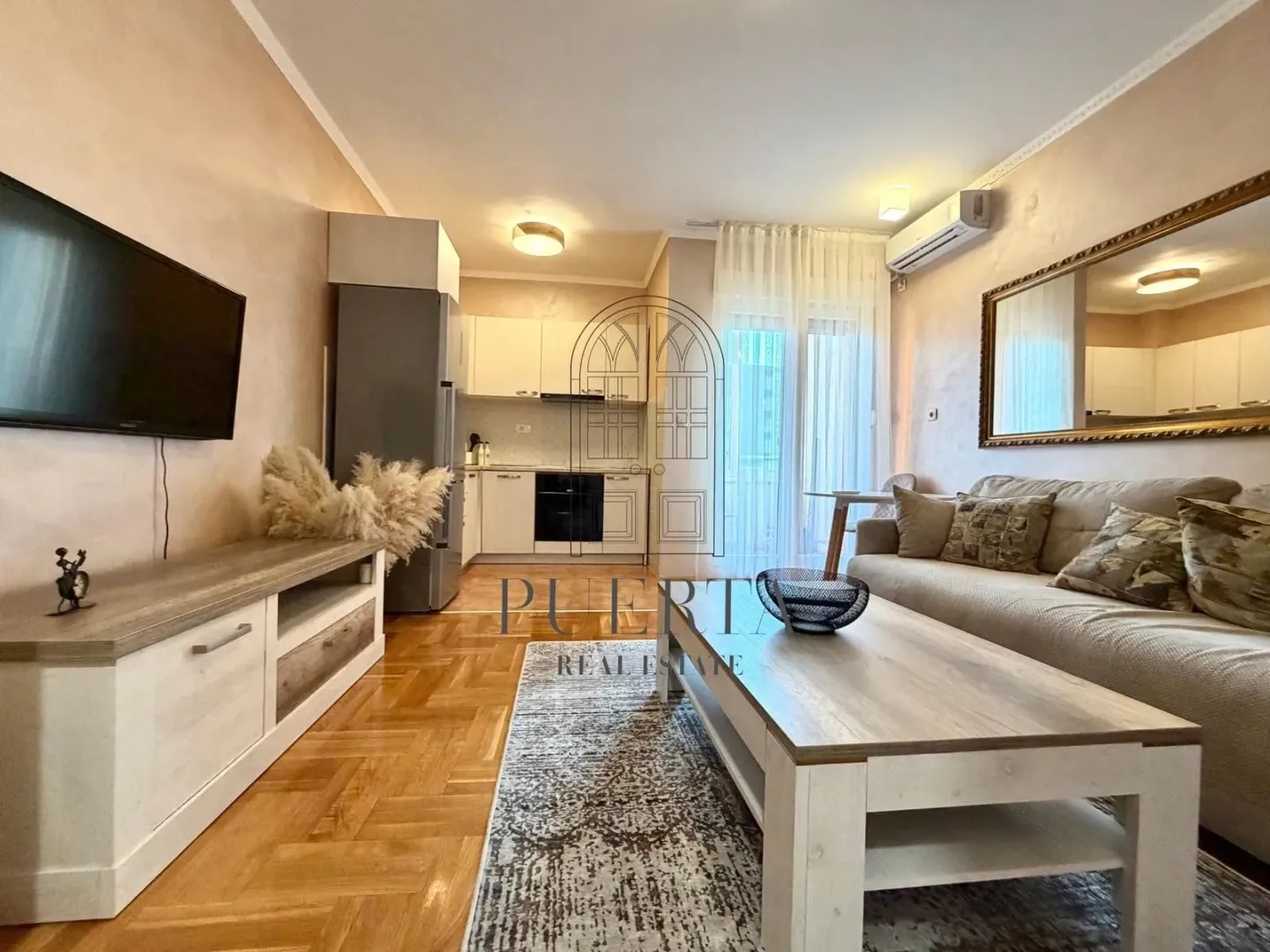 Living room with a sofa and dining area in the background.