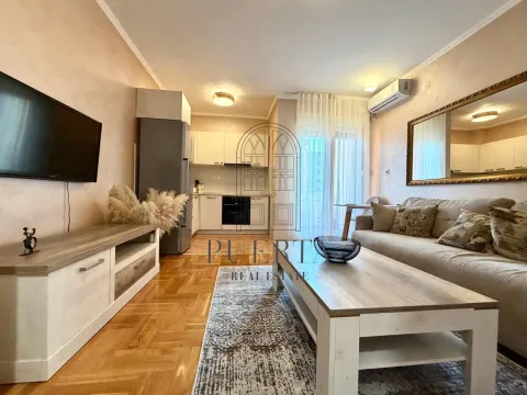 Living room with a sofa and dining area in the background. - image 4
