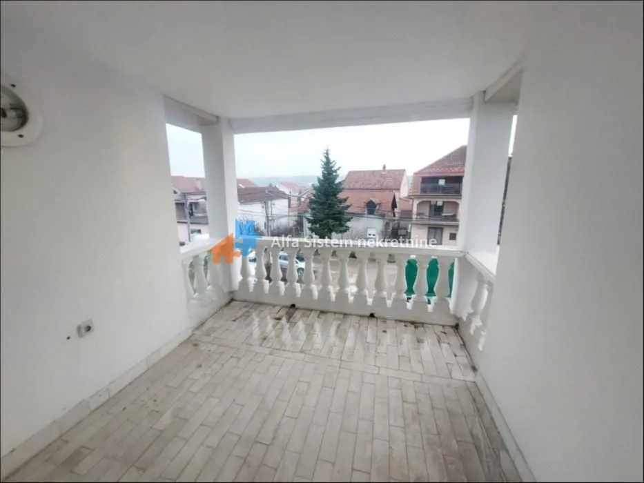 Covered balcony with tiled flooring and a neighborhood view.