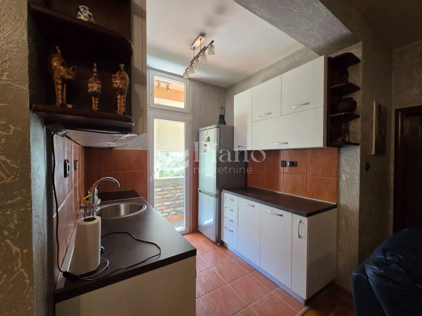 Kitchen equipped with white cabinets, a refrigerator, and a countertop.