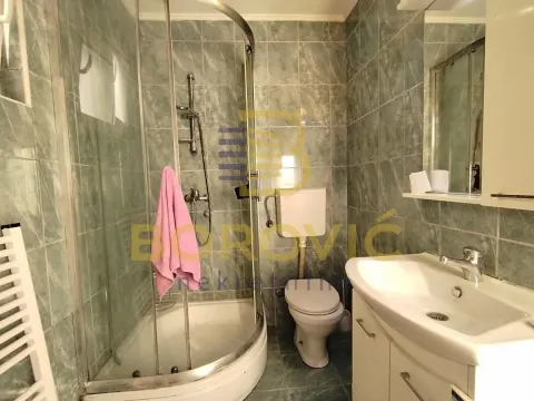 Bathroom equipped with a shower cabin, washbasin, and toilet. - image 7
