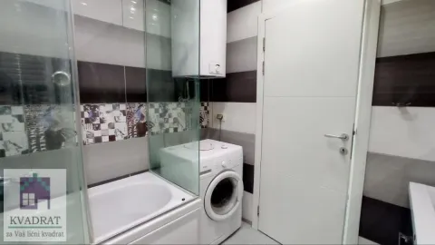 Kupatilo sa kadom, staklenom pregradom, veš mašinom i belim vratima. - image 9