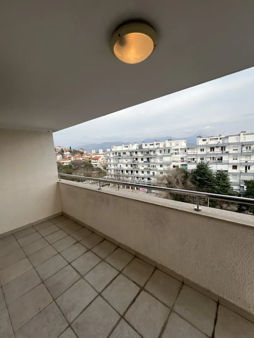 Spacious terrace with a view of the city and surrounding buildings.