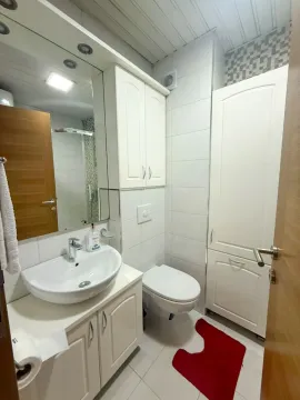 Small bathroom with white cabinetry, sink, and toilet. - image 5
