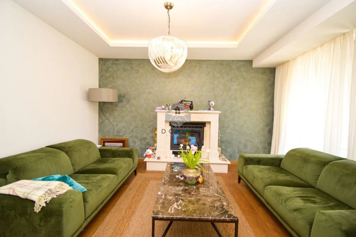 Living room with a fireplace and green sofas.